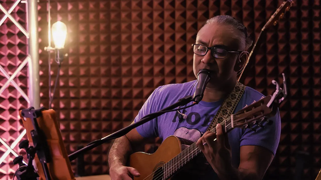 Franco singing and playing acoustic guitar
